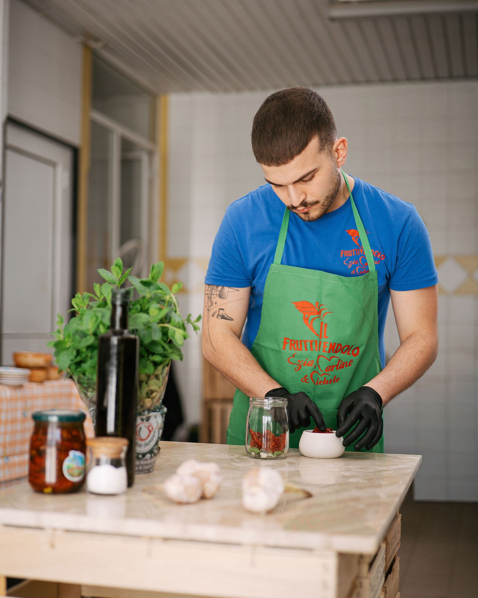 Martino prepara a mano un vasetto di sottoli nel laboratorio della bottega